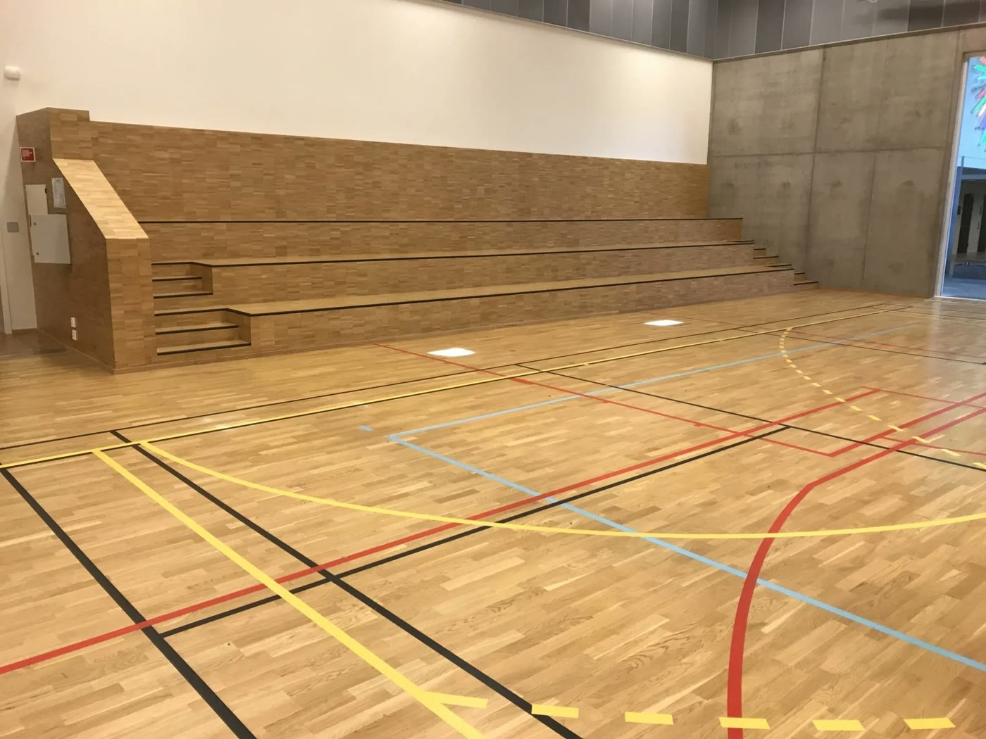 Ferdig sportsgulv med banemerking i en idrettshall med tribune